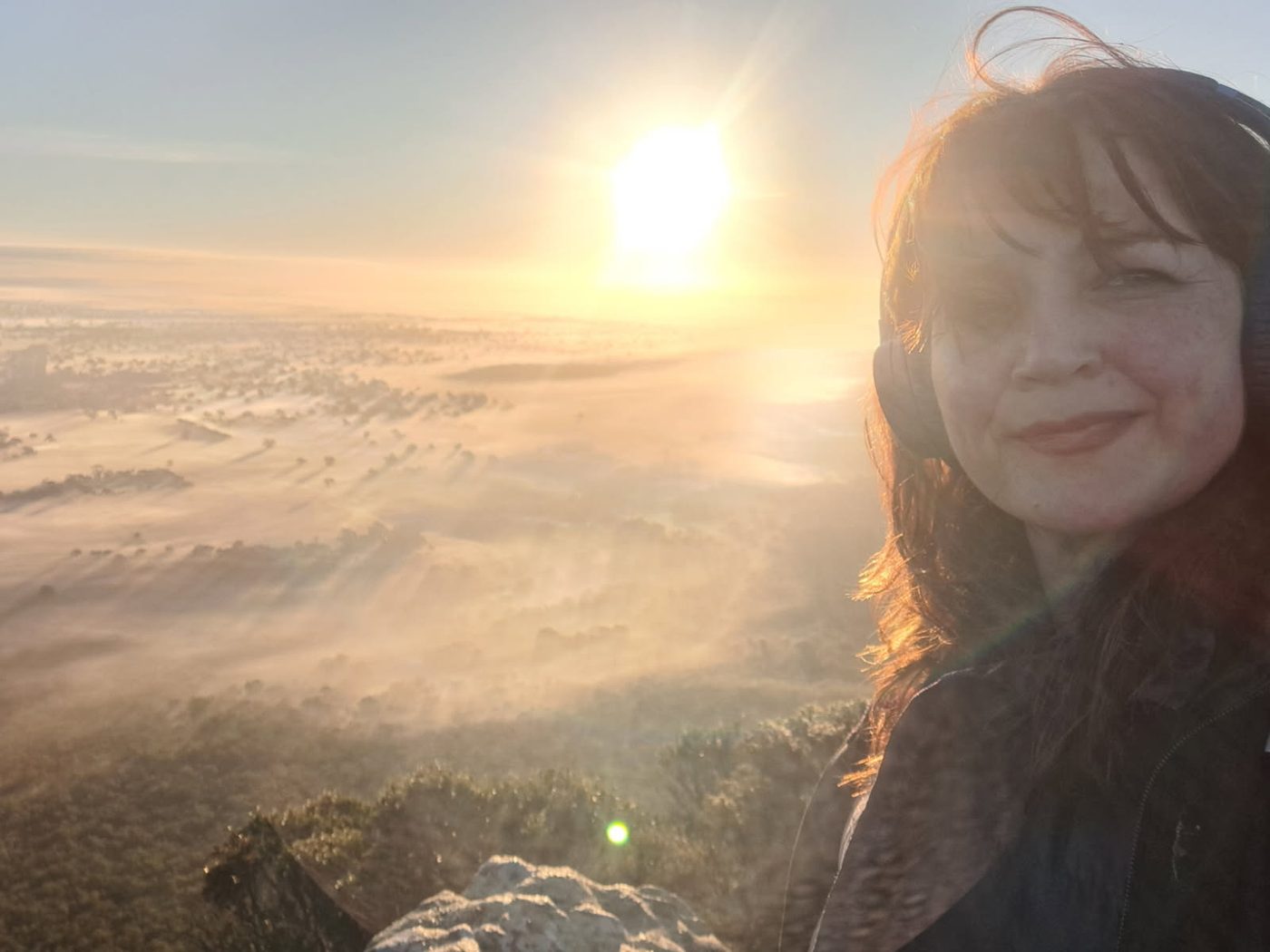Terryl Maddocks at sunrise on the mountain above Hamilton, Victoria, with mist lying over the plains below